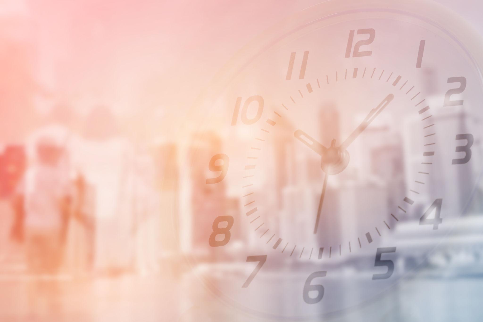 Double exposure of clock and people walking with blurred building